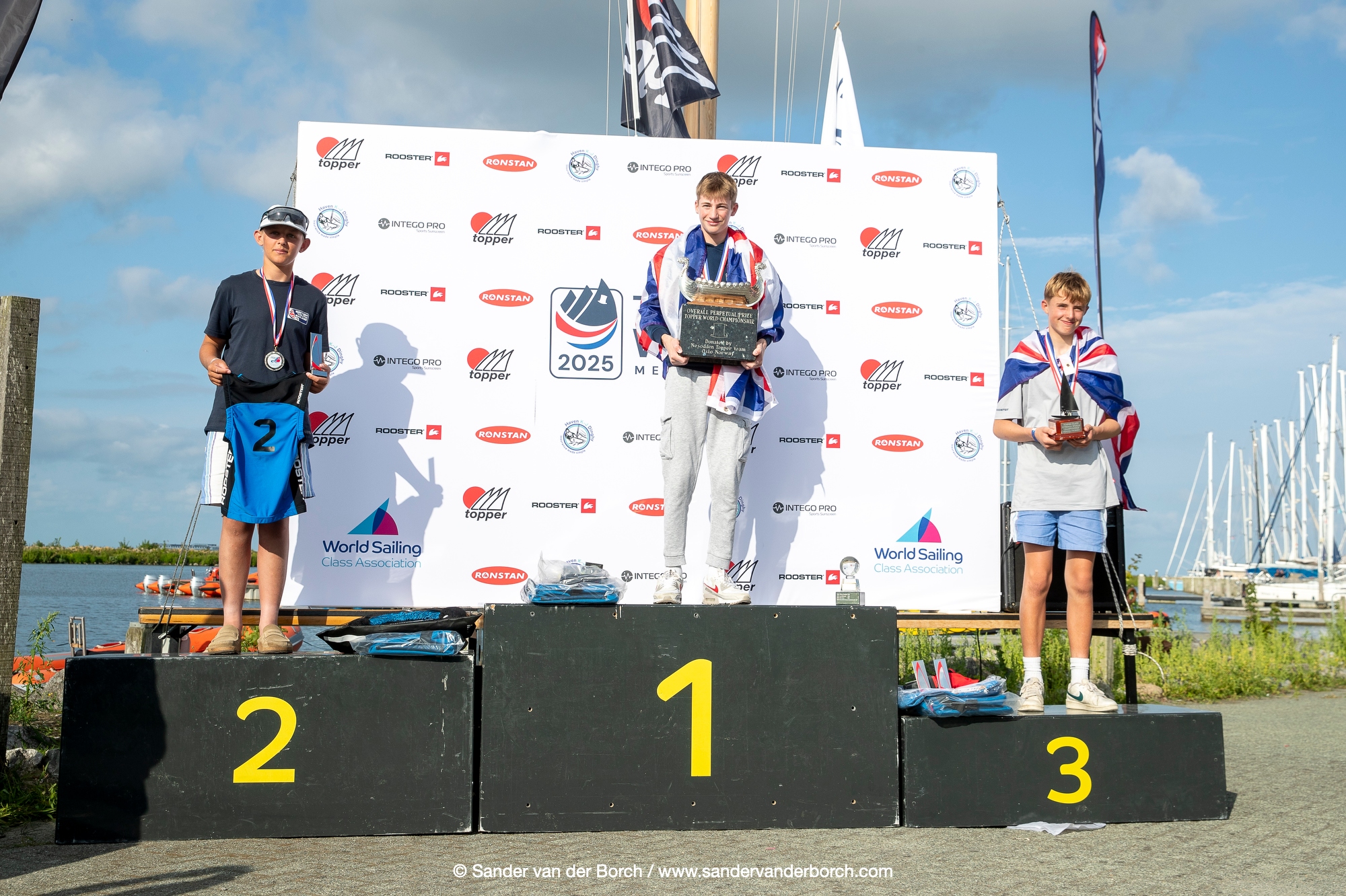 Topper World Champion 2024 Che Liu (CHN) medalist on the Podium, with national flags wrapped around them
